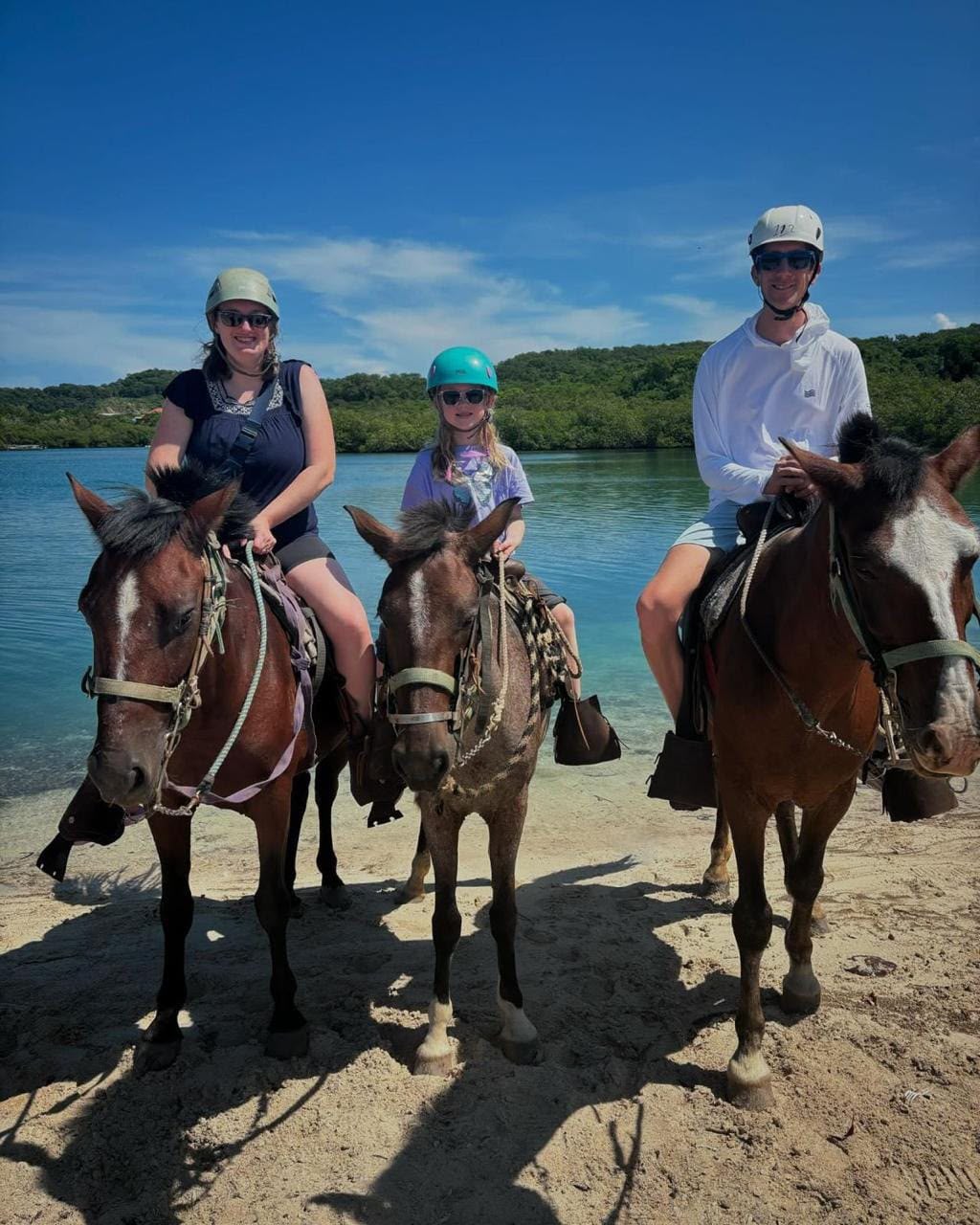 Family enjoying a horseback ride by the sea in Roatán